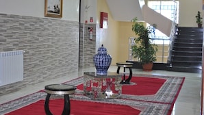 A hotel lobby with a staircase, a large blue vase, and a red carpet. - Maraval Hotel Oran (Oran)