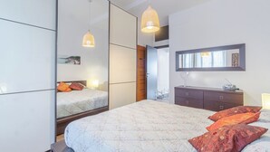 Um quarto moderno com uma cama grande, uma cômoda e um espelho na parede.