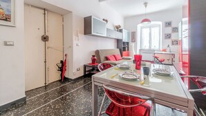 Cozinha moderna com mesa de jantar, cadeiras e geladeira.