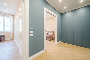 Una habitación amplia con piso de madera claro, un armario grande y una puerta que da a otra habitación.