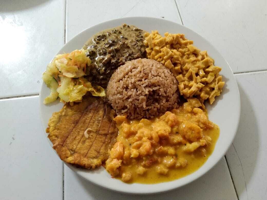 Un piatto con riso, maccheroni, una fetta di platano fritto e fagioli.