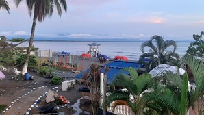 Une zone de plage avec des tentes, une bouée de sauvetage et une vue sur la mer.