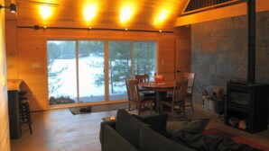 L’intérieur d’un chalet accueillant, avec un coin repas, un canapé et une cheminée.