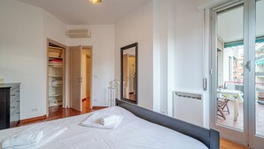A bedroom with a large bed, a wardrobe, and a sliding glass door to a balcony. - Genoa Getaway! Sturla Comfy Flat X2 Free Parking (Genoa)