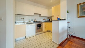 A modern kitchen with white cabinets, stainless steel appliances, and a wooden floor. - Genoa Getaway! Sturla Comfy Flat X2 Free Parking (Genoa)