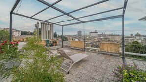 A rooftop terrace with metal railings, two lounge chairs, and potted plants. - Bright Apartment A Few Steps From Via Garibaldi (Genoa)