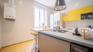 A modern kitchen with a built-in stove, a kettle, and a sink. - Bright Apartment A Few Steps From Via Garibaldi (Genoa)