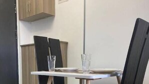 Un'area pranzo con tavolo e sedie, un armadio e una porta.