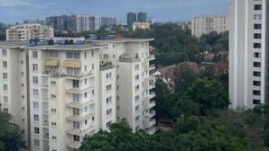 Un edificio residenziale a più piani con balconi, immerso nel verde e circondato da altri edifici.