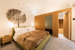 A bedroom with a bed, bedside table, and a wall-mounted artwork. - Apartments Florence- Dragomanni Loft (two) with garden (Firenze)