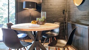 A round wooden table with a book, two glass vases with plants, and black chairs. - Nice home in Rheezerveen with sauna (Rheezerveen)