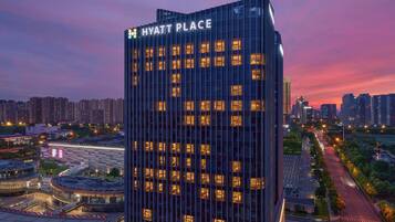 Un hotel moderno de gran altura, con fachada de vidrio y ventanas iluminadas.