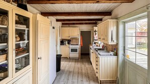 A narrow kitchen with wooden cabinets, a stove, and a window. - Amazing home in Jonstorp with kitchen (Jonstorp)