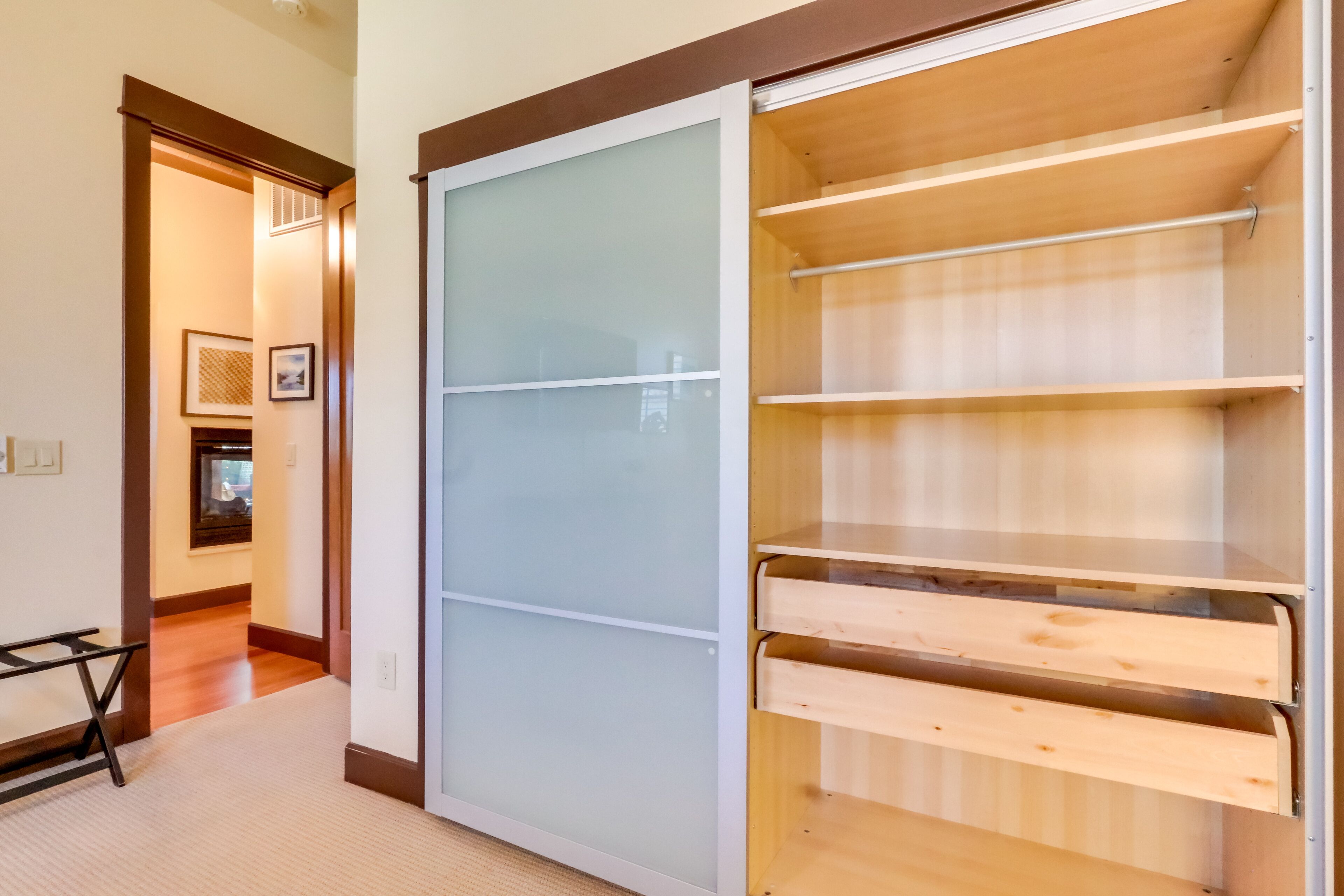 Un dressing avec des portes coulissantes et de nombreuses étagères.