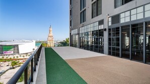A rooftop terrace with a clear view of a historic building and a modern sports complex. - Cityview Studio King (Miami)