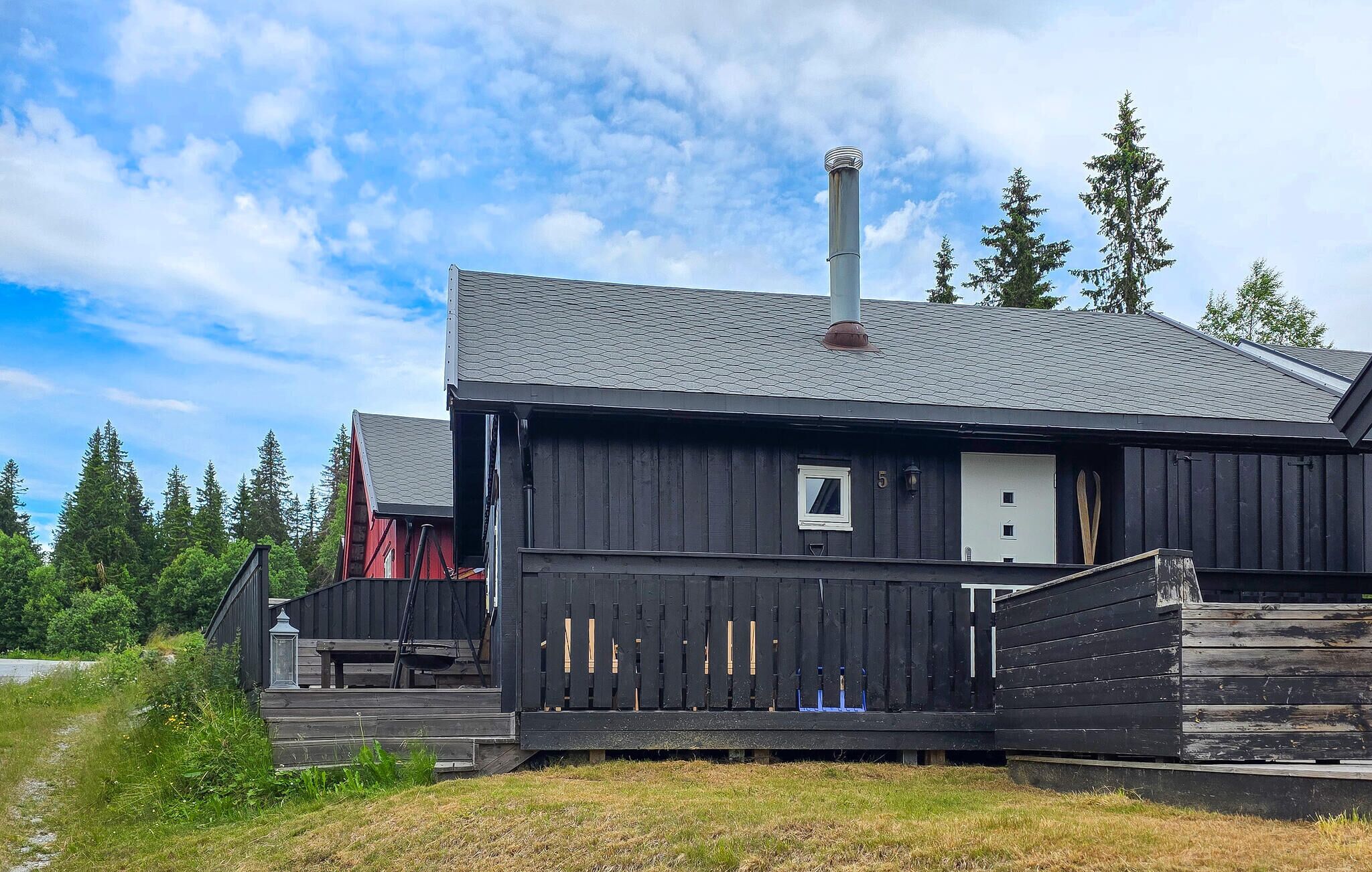 A rustic cabin with a chimney, a small window, and a door.