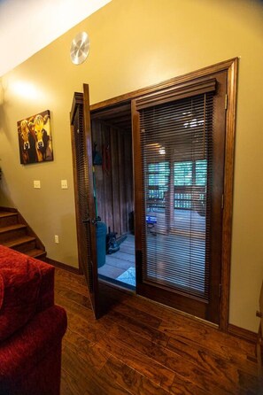 A wooden-framed sliding door leading to an outdoor patio area with a view of a backyard.