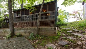 A wooden deck leading to a building with a balcony.