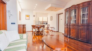 Un vaste espace de vie comprenant une table à manger, des meubles en bois et une cuisine à l’arrière-plan.