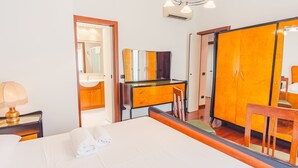 A hotel room with a bed, a desk, a chair, a mirror, and a wardrobe. - Residenza Edvige - Italian Homing (Verona)