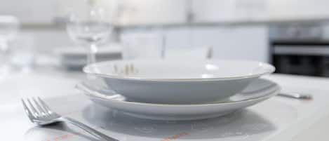 A dining table set with a white plate, a bowl, and a fork.