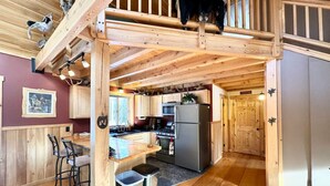 A wooden interior with a kitchen, bar area, and a loft space. - Caddis Ridge Camp|West Forks with Trail Access (West Forks)