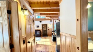A wooden hallway with doors, a bench, and a trash can. - Caddis Ridge Camp|West Forks with Trail Access (West Forks)