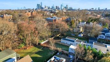 Un quartier résidentiel avec des maisons modernes, une grande pelouse verdoyante et, en arrière-plan, le panorama de la ville.