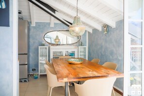 A dining area with a wooden table, white chairs, a decorative chandelier, and a view of the kitchen in the background. - Enjoy a splendid view of Lake Como from this elegant apartment behind the enchanting village of Bellano.General Terms and Conditions - Vacation Rental:Welcome to our vacation rental. To ensure a pleasant and hassle-free stay, please review the following  (Bellano)