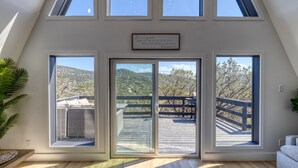 Um quarto com grandes janelas, um deck de madeira e uma placa sobre as janelas.