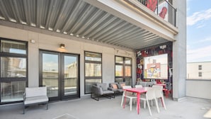 A rooftop patio with outdoor seating, large windows, and a view of the city. - Art District Dream | RiNo Art Lofts (Denver)