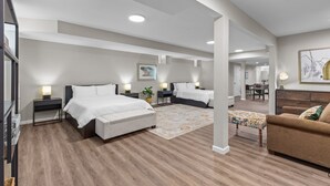 Une chambre moderne avec deux lits, un canapé et un coin repas.