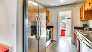 A modern kitchen with stainless steel appliances, wooden cabinets, and a red trash bin. - Strip View! Retreat 4 Mi to Silver Dollar City (Branson)