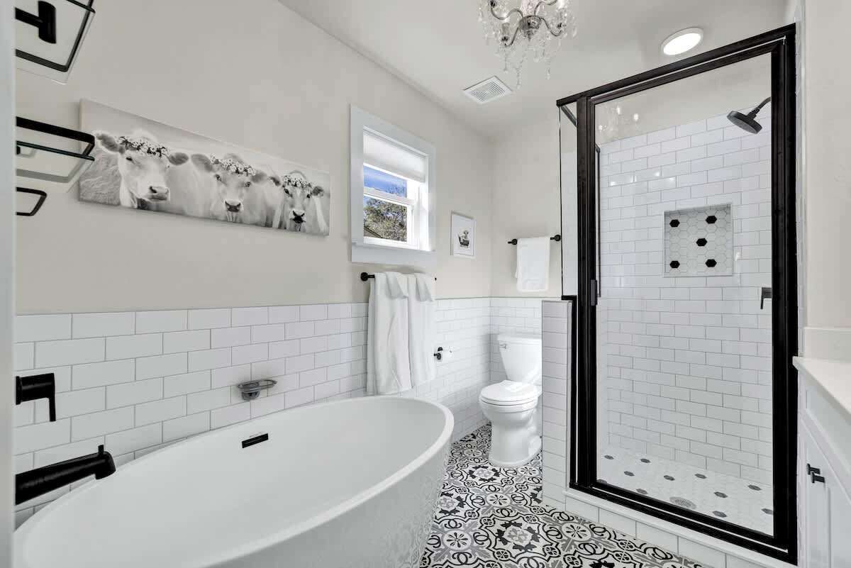 A modern bathroom with a freestanding bathtub, a toilet, and a glass-enclosed shower.
