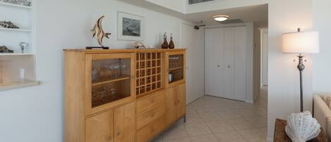 A hallway with a wooden cabinet, a framed picture, and a lamp.
