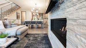 Ein modernes Interieur mit Treppe, Essbereich und Kamin.