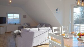 Un espace de vie moderne de style loft, comprenant un canapé, une table à manger et des chaises.