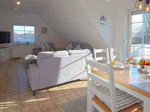 Ein moderner Loft-Wohnraum mit Sofa, Esstisch und Stühlen.