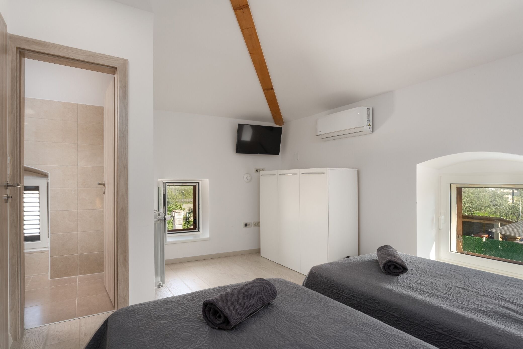Ein Schlafzimmer mit zwei Betten, einem Fernseher und einem Kleiderschrank.