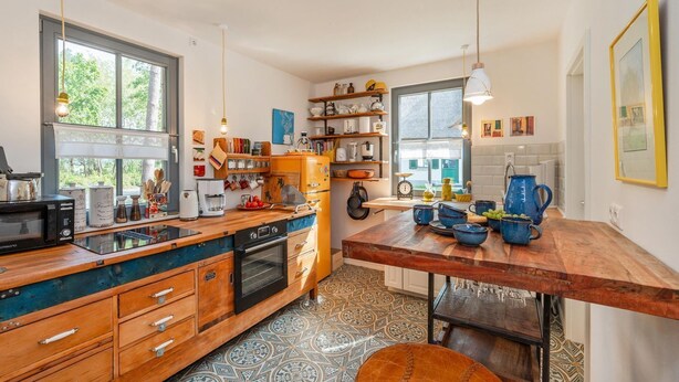Une cuisine dotée d’un plan de travail en bois, d’un four encastré et d’une machine à café.
