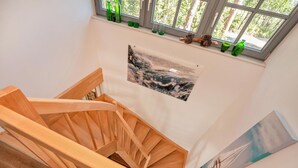 Un escalier en bois offrant une vue sur une forêt à travers une fenêtre.
