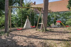 Un parque infantil con columpios, tobogán y estructura para escalar.