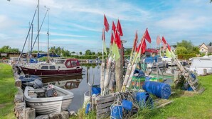 A marina with boats docked, wooden posts, and various equipment.