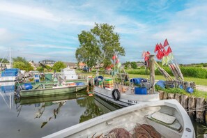 Un port de plaisance avec des bateaux amarrés, une zone herbeuse et un ciel dégagé.