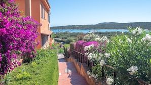 Un sendero que lleva a un edificio con vistas a un lago y colinas.