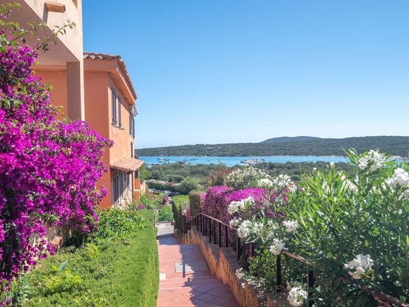 A pathway leading to a building with a view of a lake and hills.