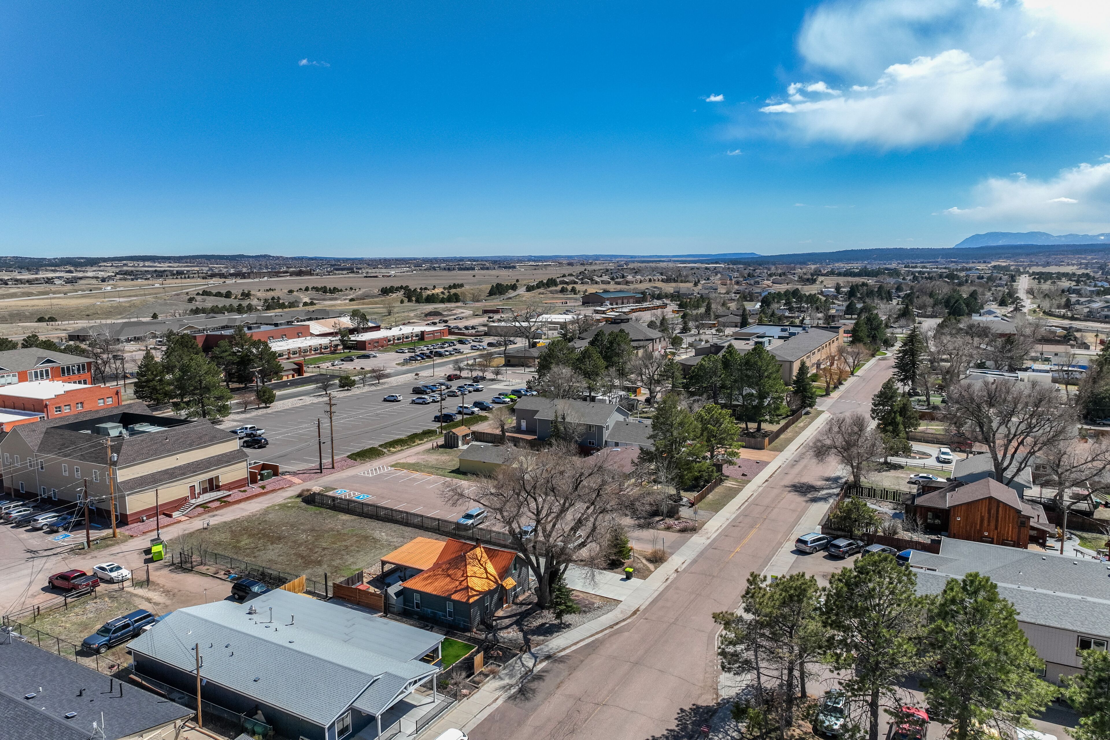 An aerial view of a town with various buildings, roads, and a clear sky.
