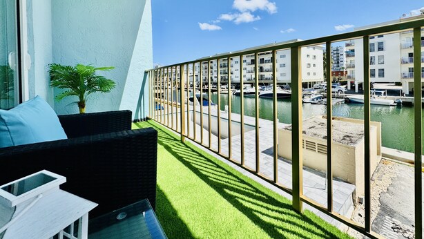 Un balcón con vista a un puerto deportivo y edificios.