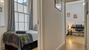Un dormitorio con cama, escritorio y silla.