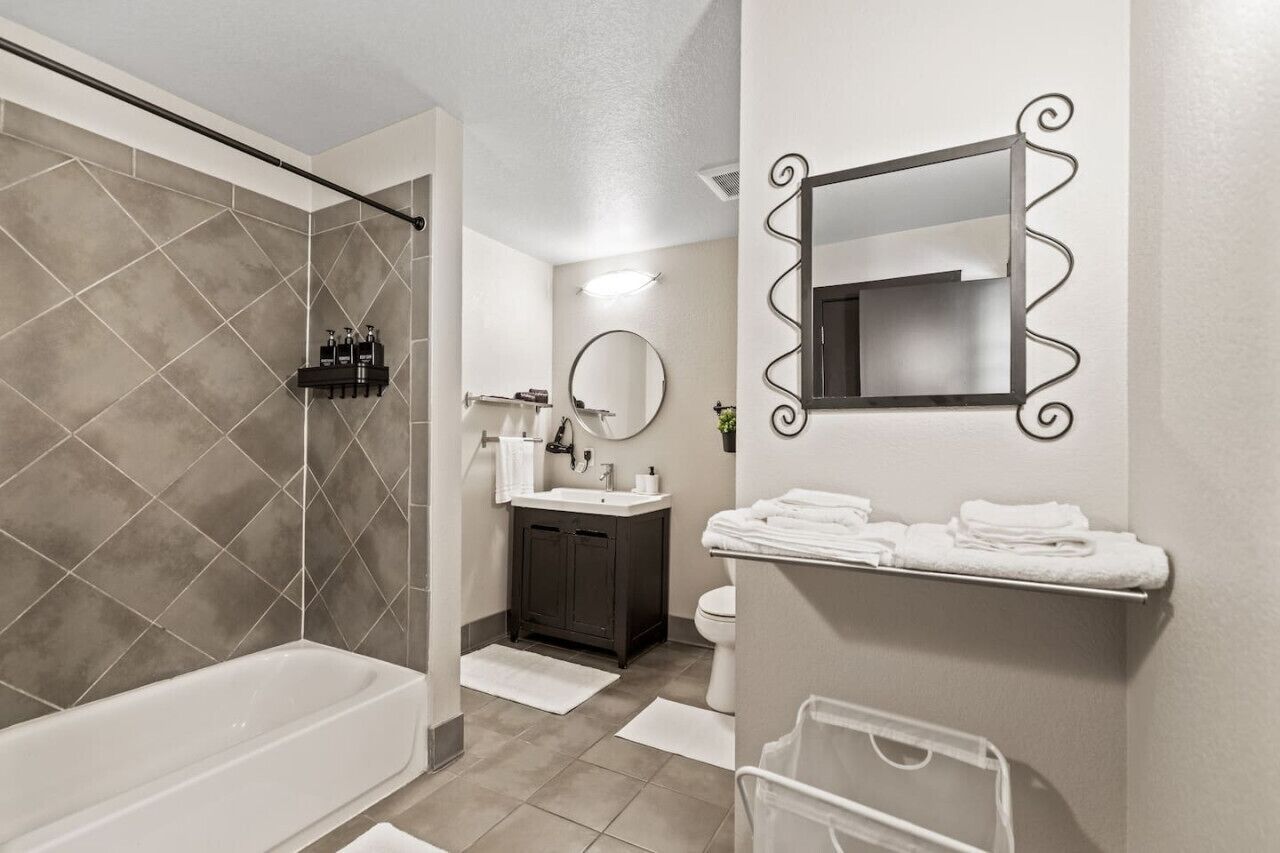 Un bagno moderno con una vasca, una doccia, un lavandino e un water.